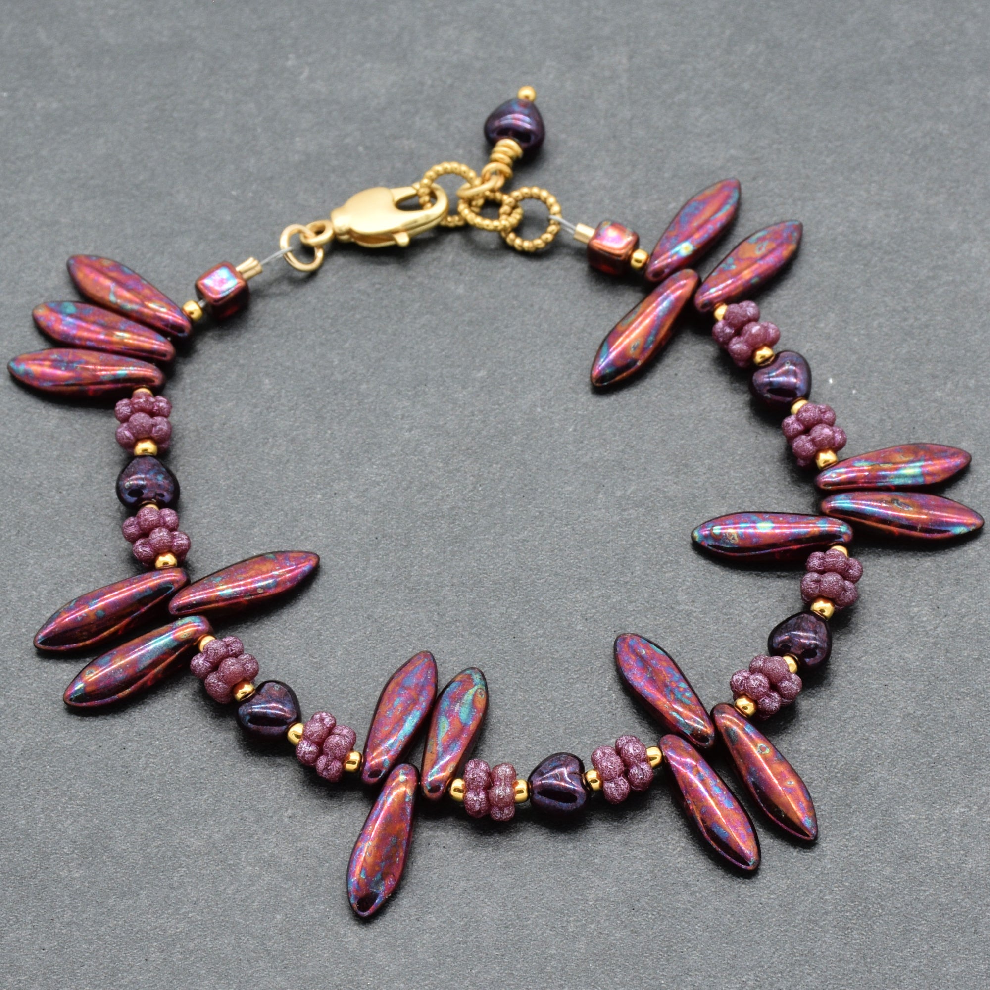 Beaded bracelet with burgundy beads on a gray background