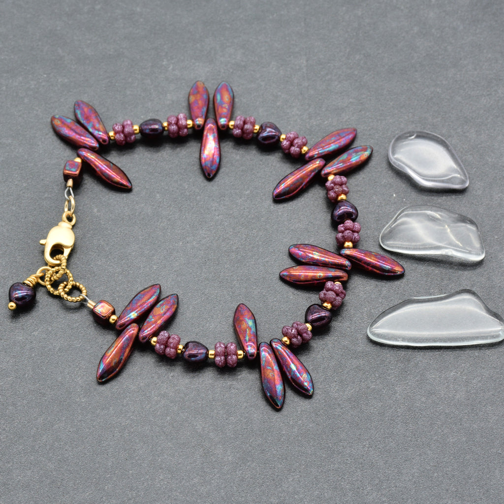 Beaded bracelet with gold clasp on a gray background