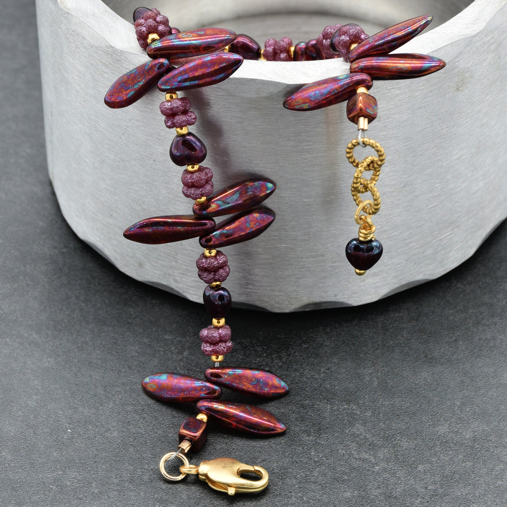 Beaded bracelet with gold accents on a stone surface