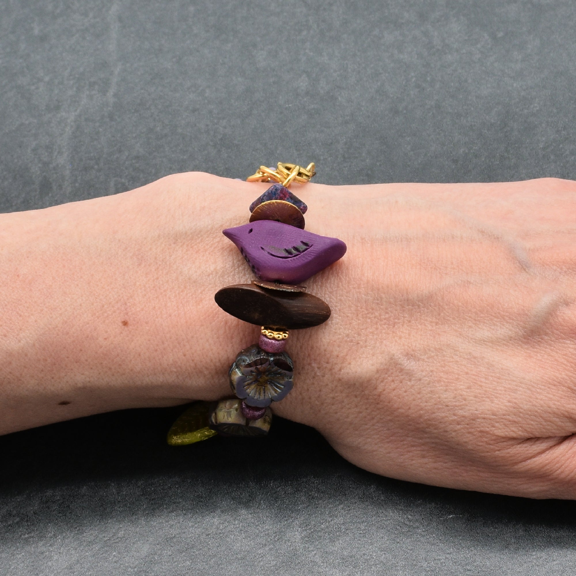 Bracelet with colorful beads on a wrist against a gray background