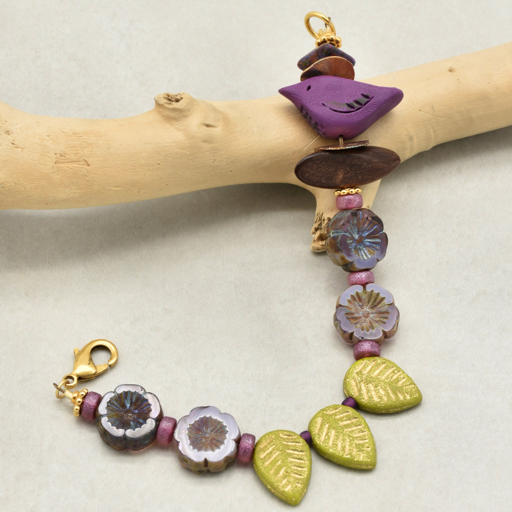Handmade bracelet with colorful beads on a wooden branch
