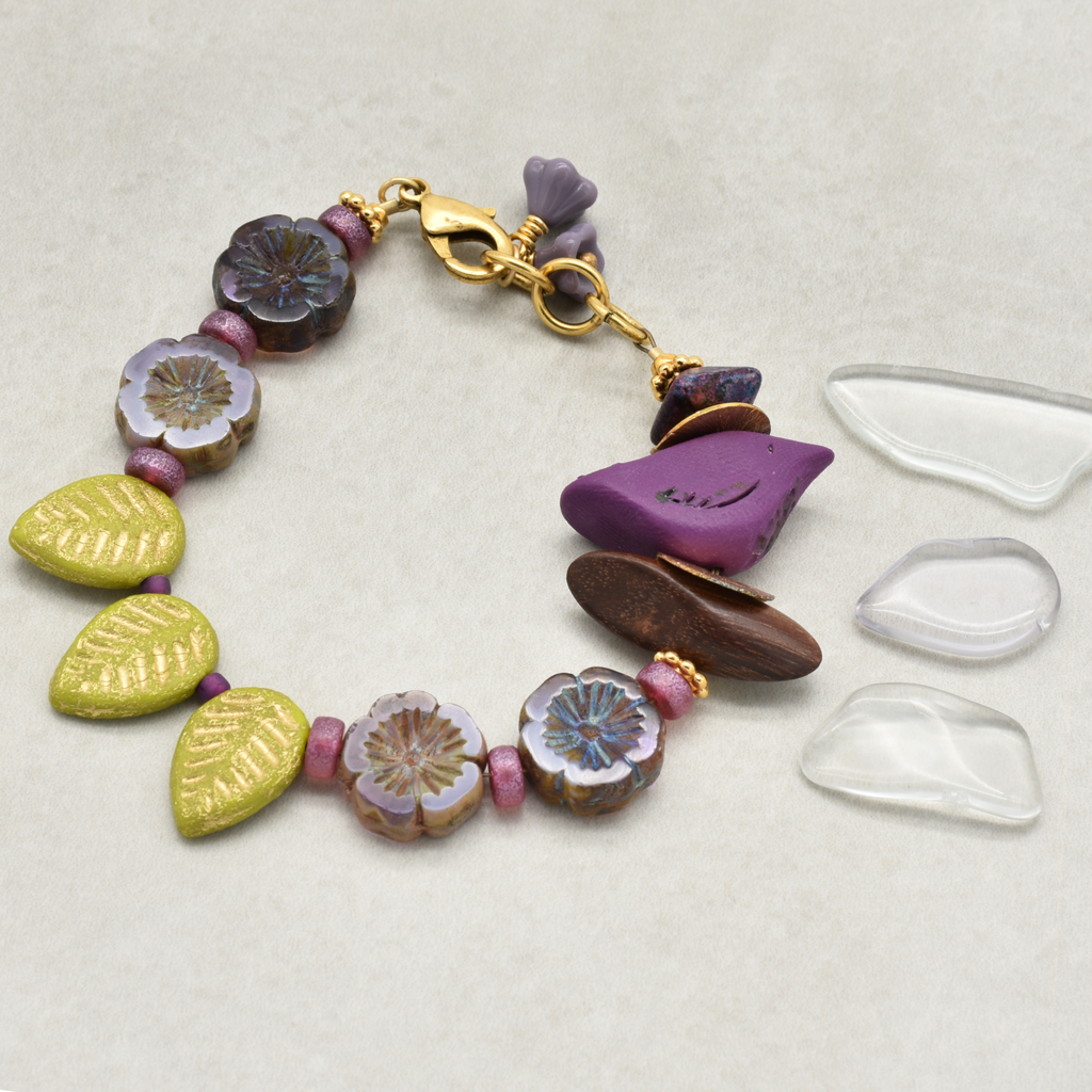 Colorful beaded bracelet with a purple bird focal on a light gray background