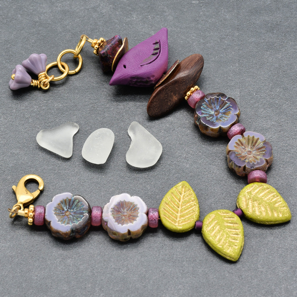 Colorful beaded bracelet with leaf-shaped beads on a gray background
