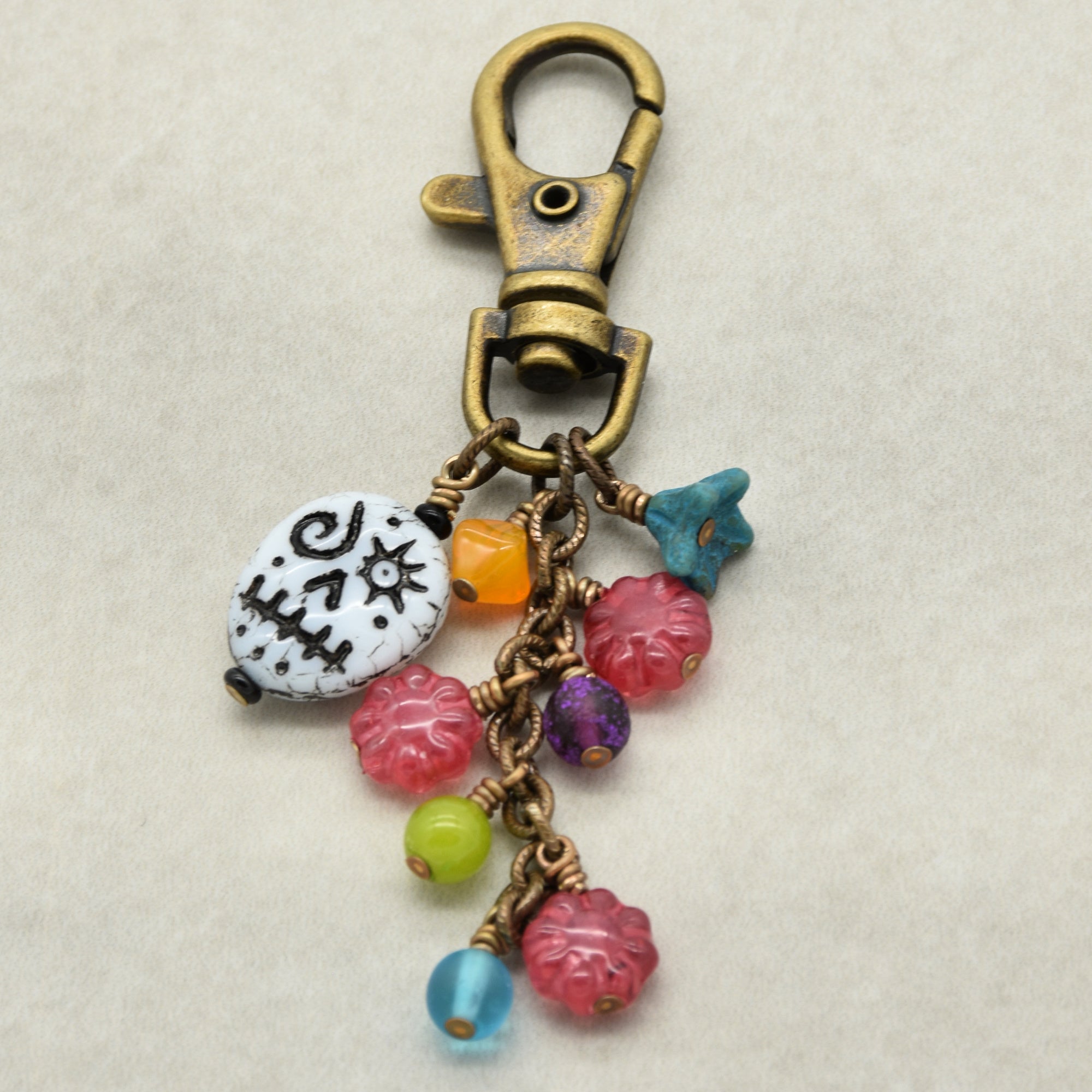 Colorful keychain with beads and a clasp on a beige background
