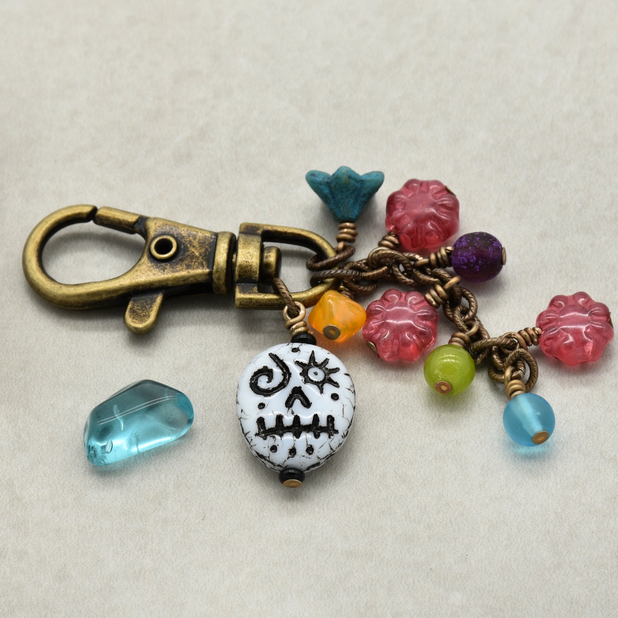 Colorful keychain with skull charm on a beige background