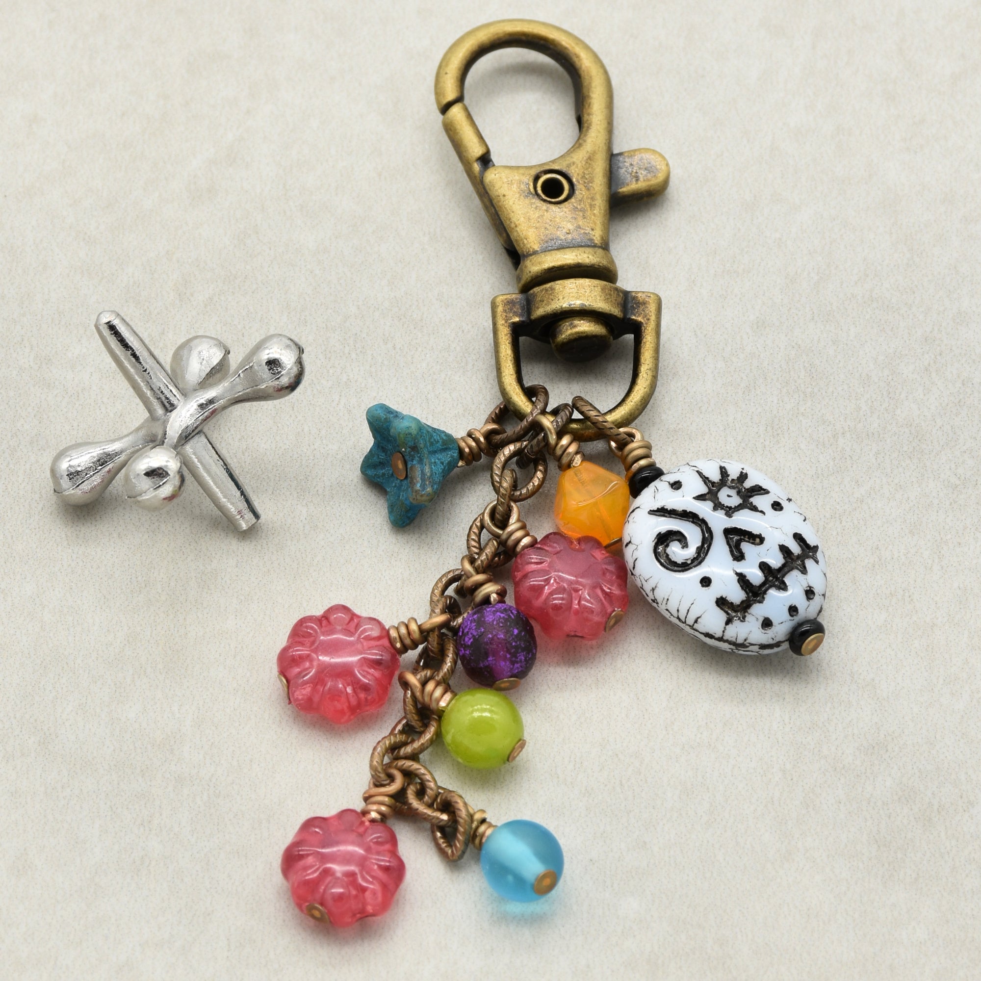 Colorful keychain with various charms on a beige background