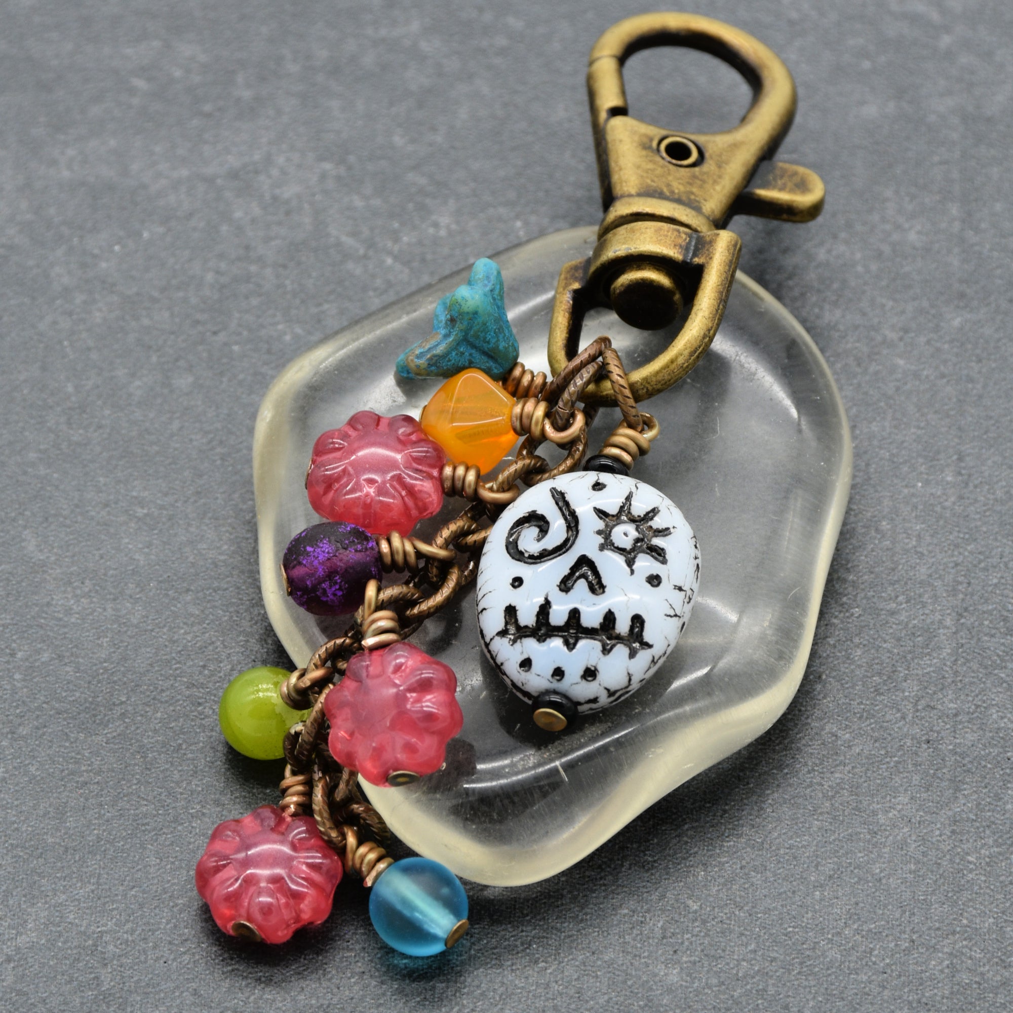 Colorful beaded keychain with a skull design on a gray background