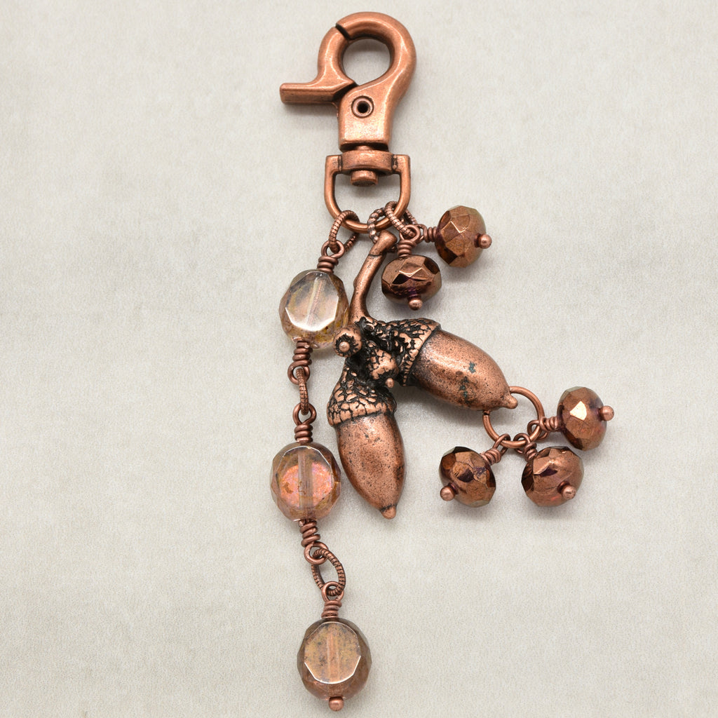 The Acorn Keeper Handbag Charm featuring a rare antique copper acorn focal with light topaz Czech glass charms, handmade by Ruby Acorn