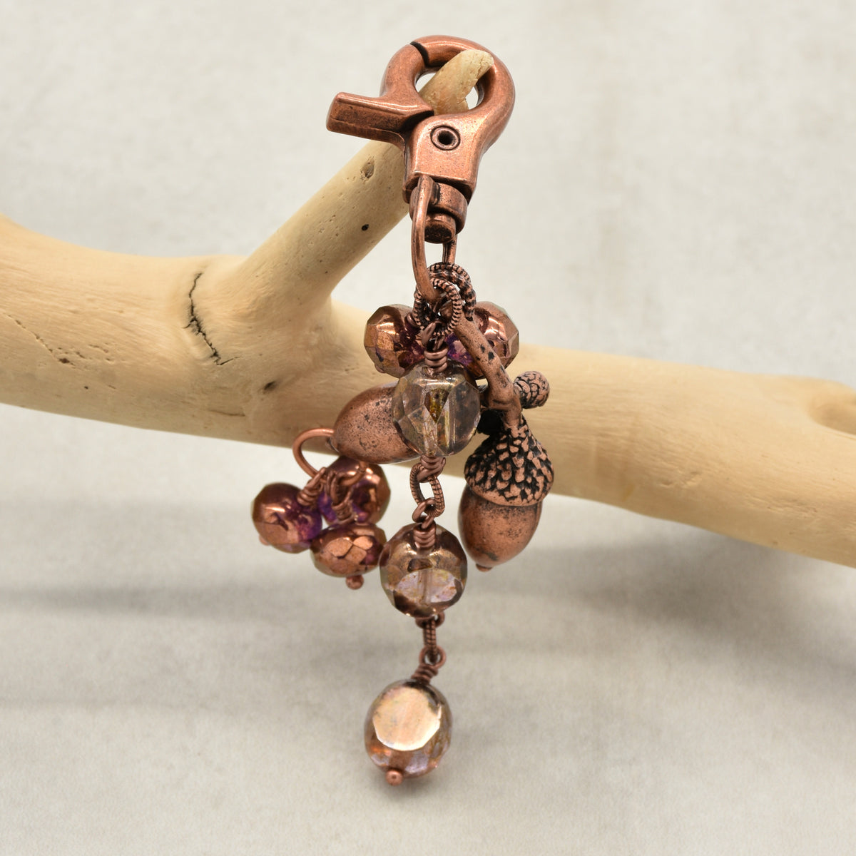 The Acorn Keeper Handbag Charm featuring a rare antique copper acorn focal with light topaz Czech glass charms, handmade by Ruby Acorn