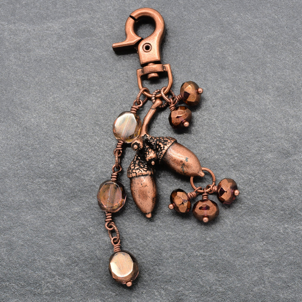 The Acorn Keeper Handbag Charm featuring a rare antique copper acorn focal with light topaz Czech glass charms, handmade by Ruby Acorn