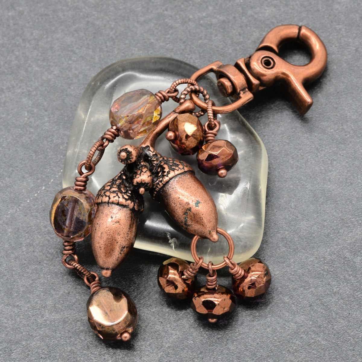 The Acorn Keeper Handbag Charm featuring a rare antique copper acorn focal with light topaz Czech glass charms, handmade by Ruby Acorn
