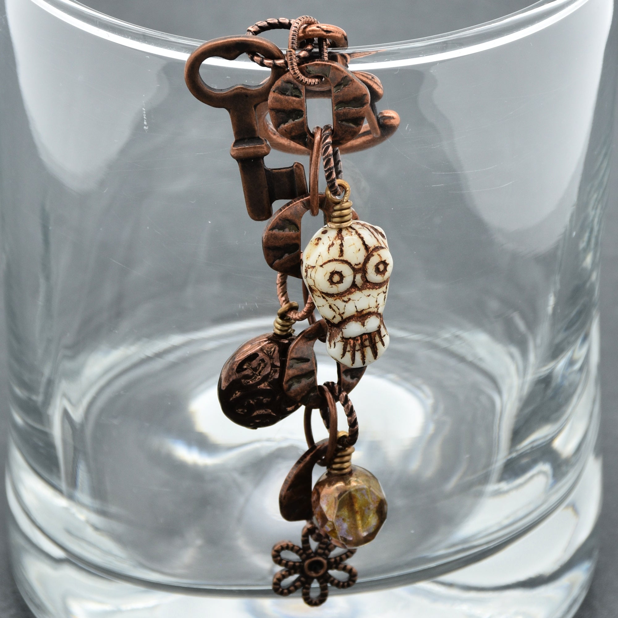 Decorative keychain with vintage-style keys and beads on a clear glass background