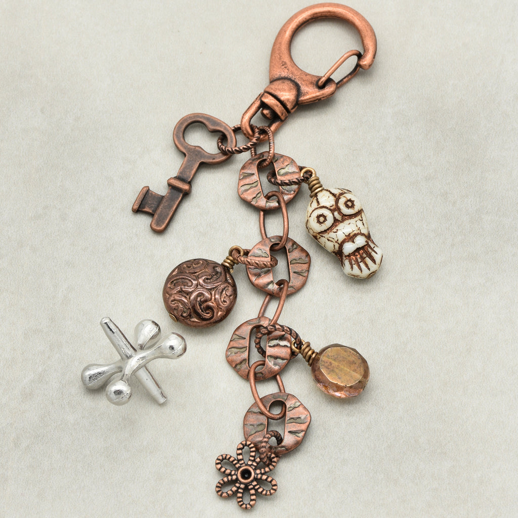 Decorative keychain with various charms on a light background