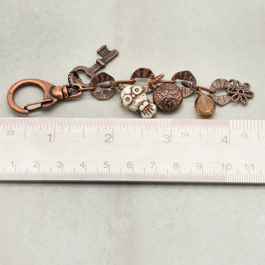 Decorative keychain with charms on a ruler for scale