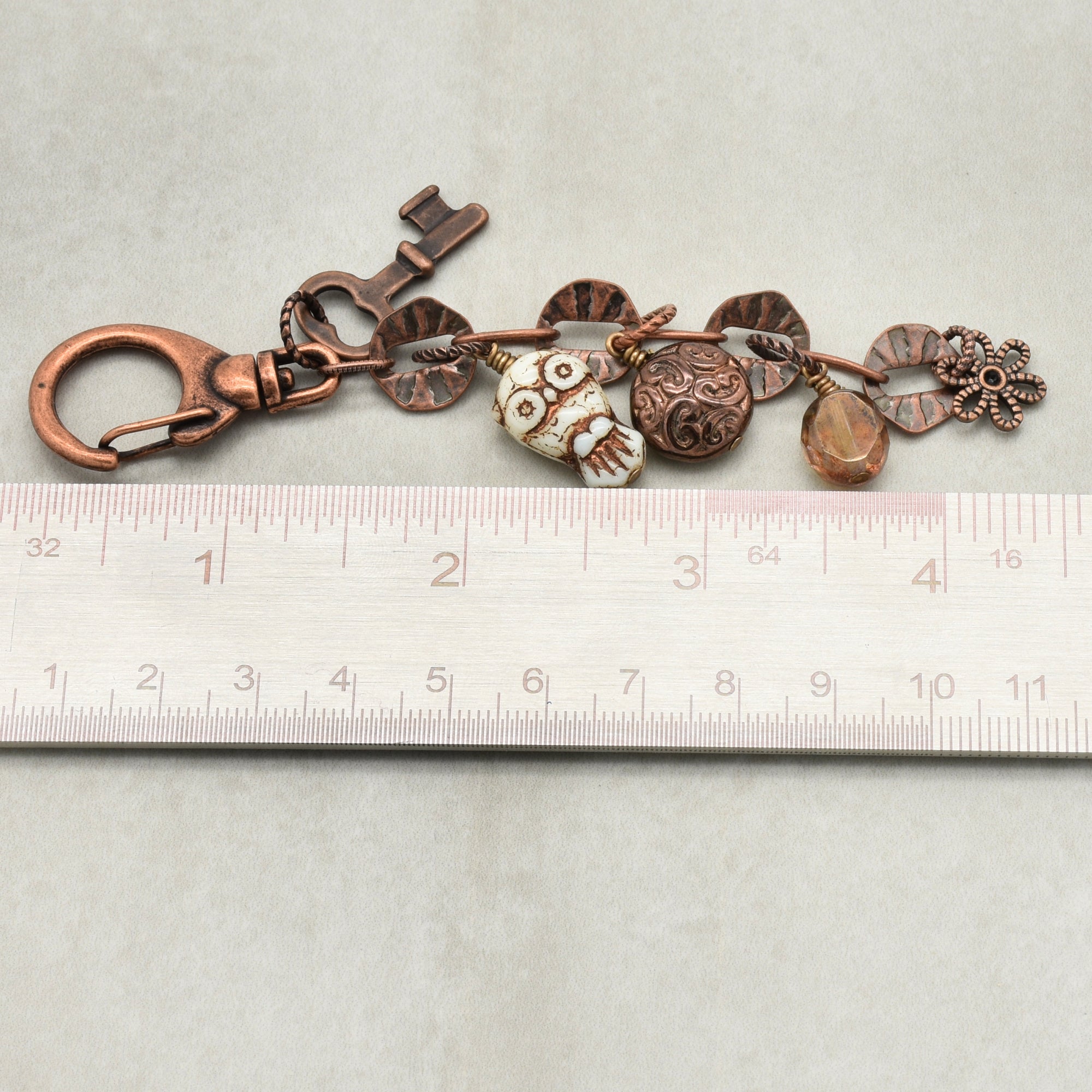Decorative keychain with charms on a ruler for scale