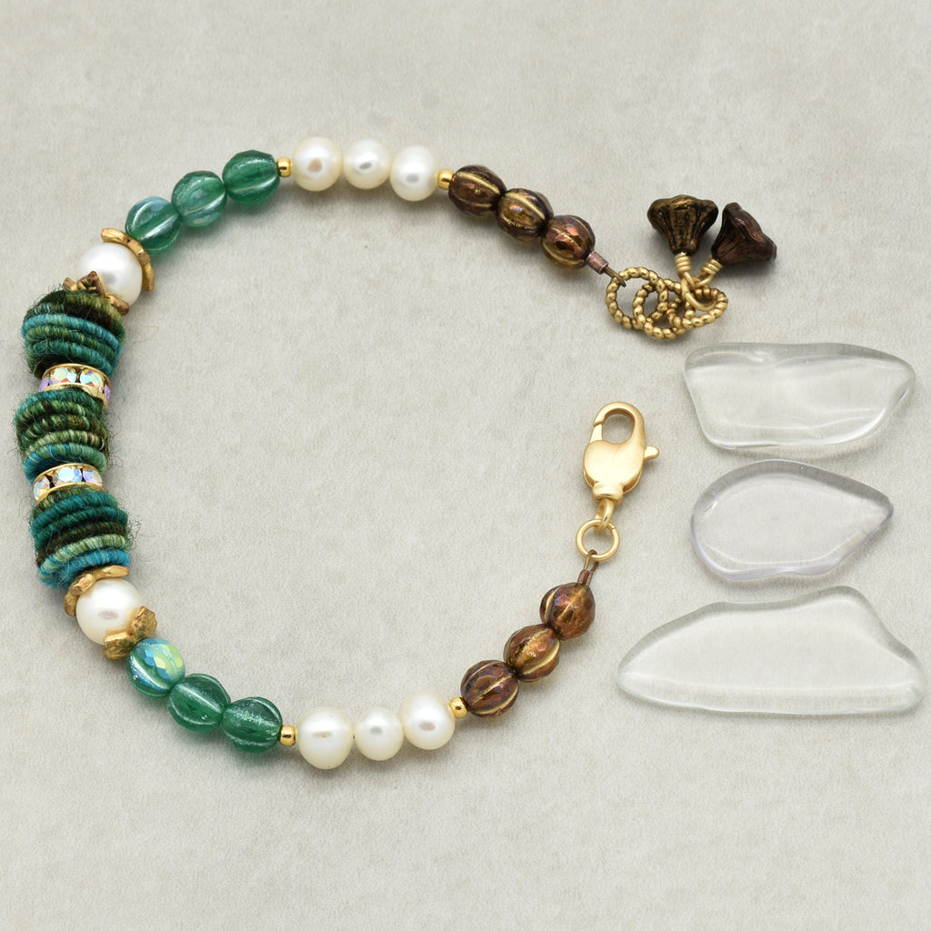 Beaded bracelet with green, brown, and white beads on a light gray background