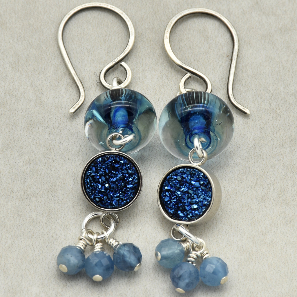 Pair of blue beaded earrings with silver hooks on a light gray background
