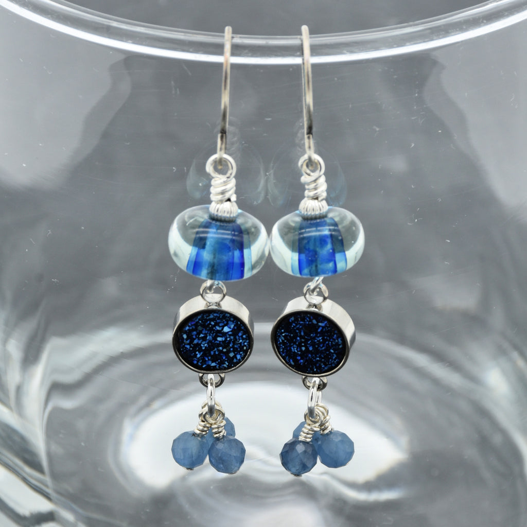 Blue beaded earrings with silver accents on a gray background