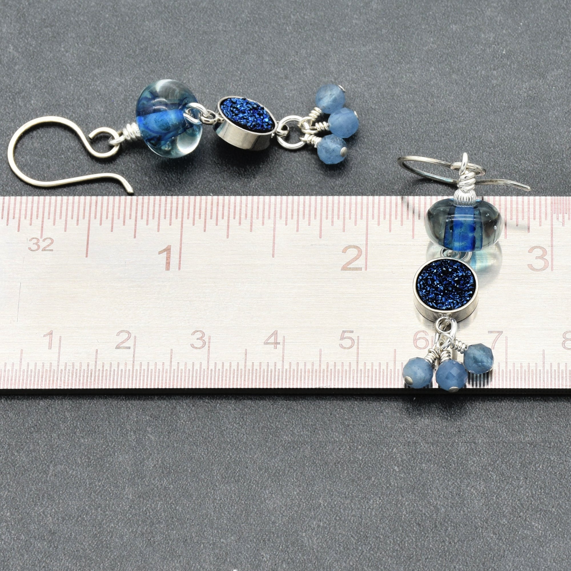 Pair of blue beaded earrings on a ruler for size reference