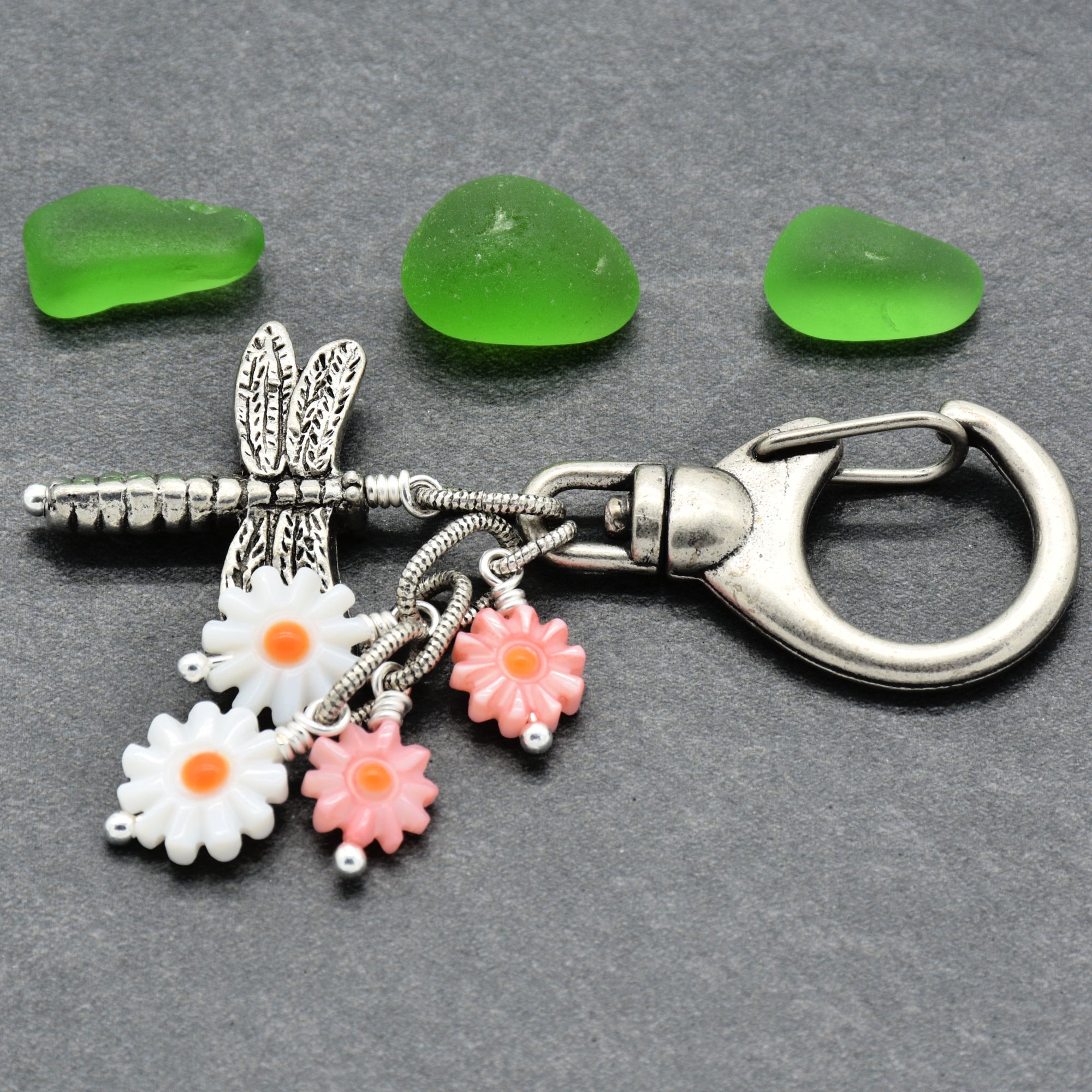 Keychain with floral charms and a dragonfly design on a gray background