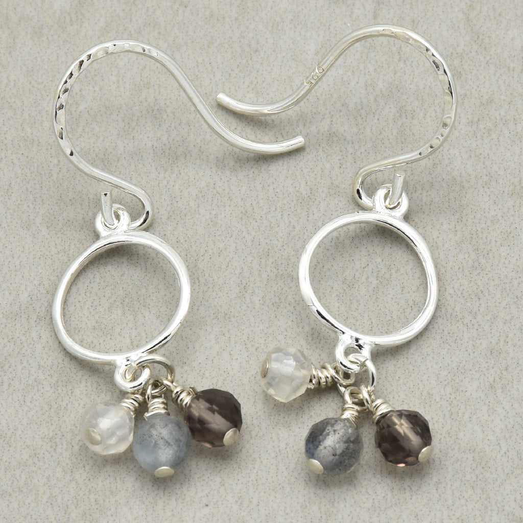 Silver earrings with small beads on a gray background