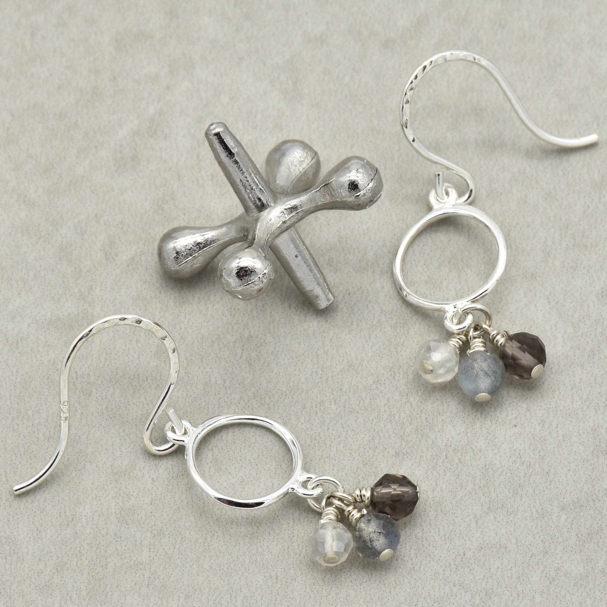  Silver earrings with gemstone drops on a gray background