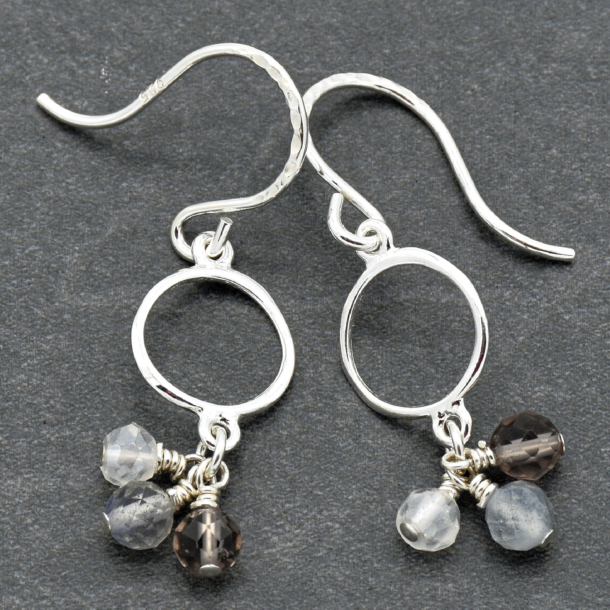 Silver earrings with small beads on a dark gray background