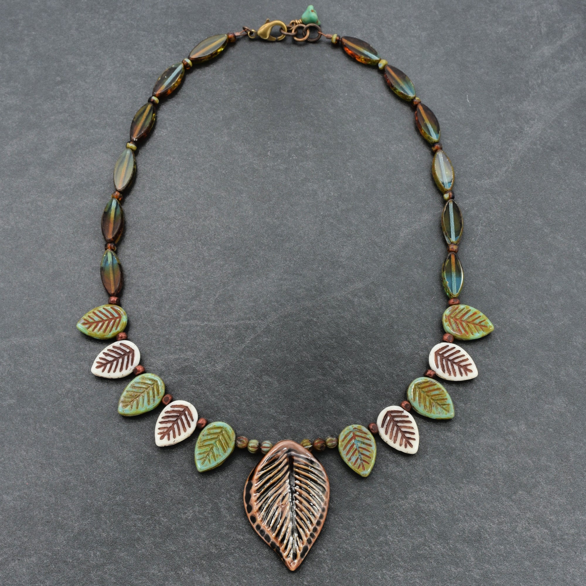 Necklace with leaf-shaped beads on a gray background