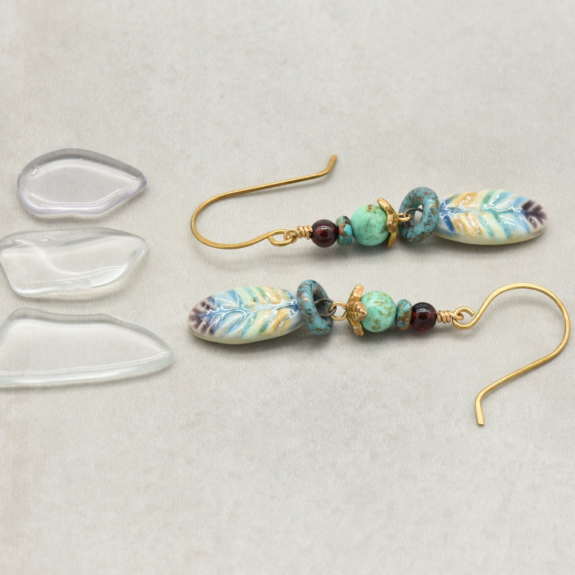 Pair of beaded earrings with brass hooks on a light gray background