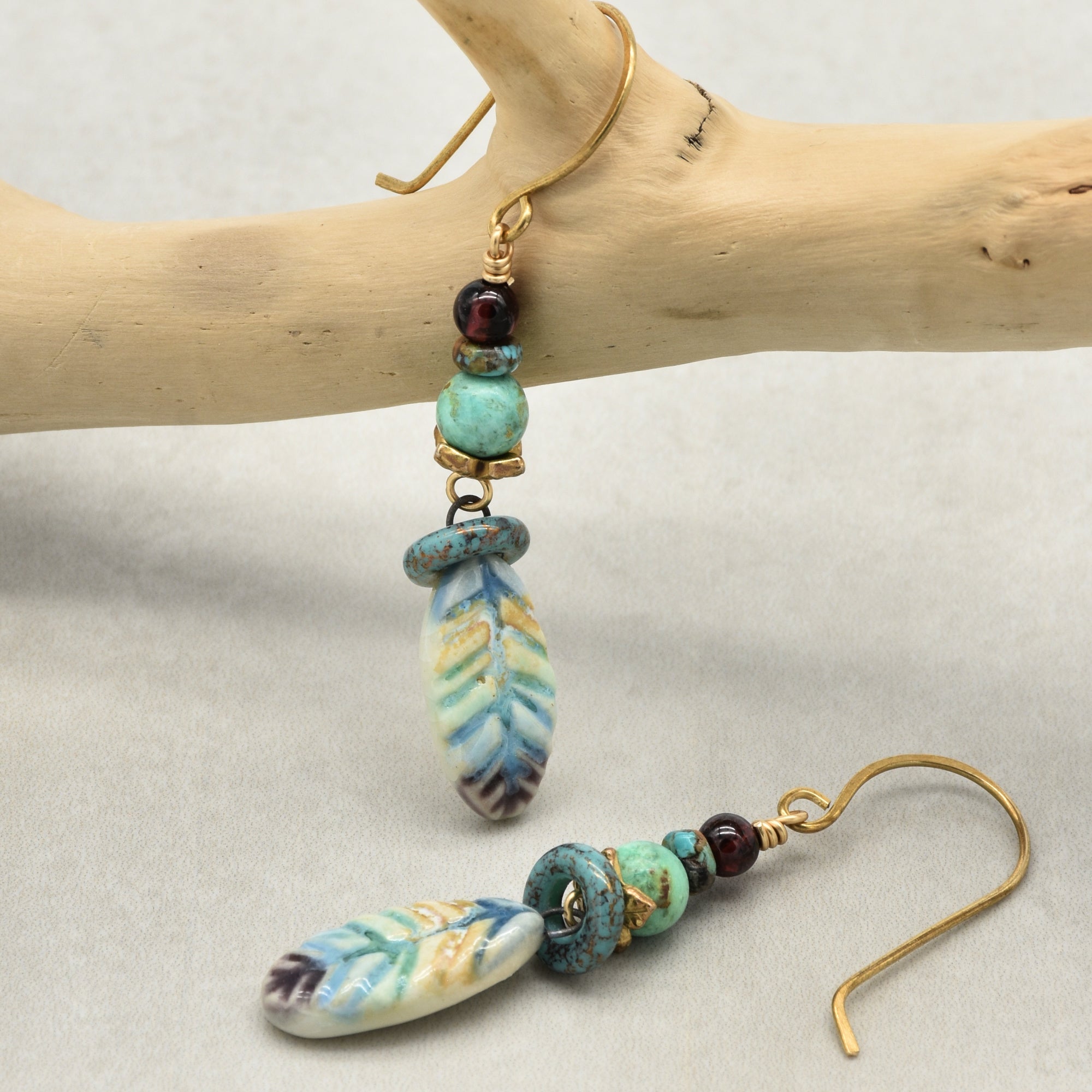 Pair of earrings with colorful beads on a wooden branch