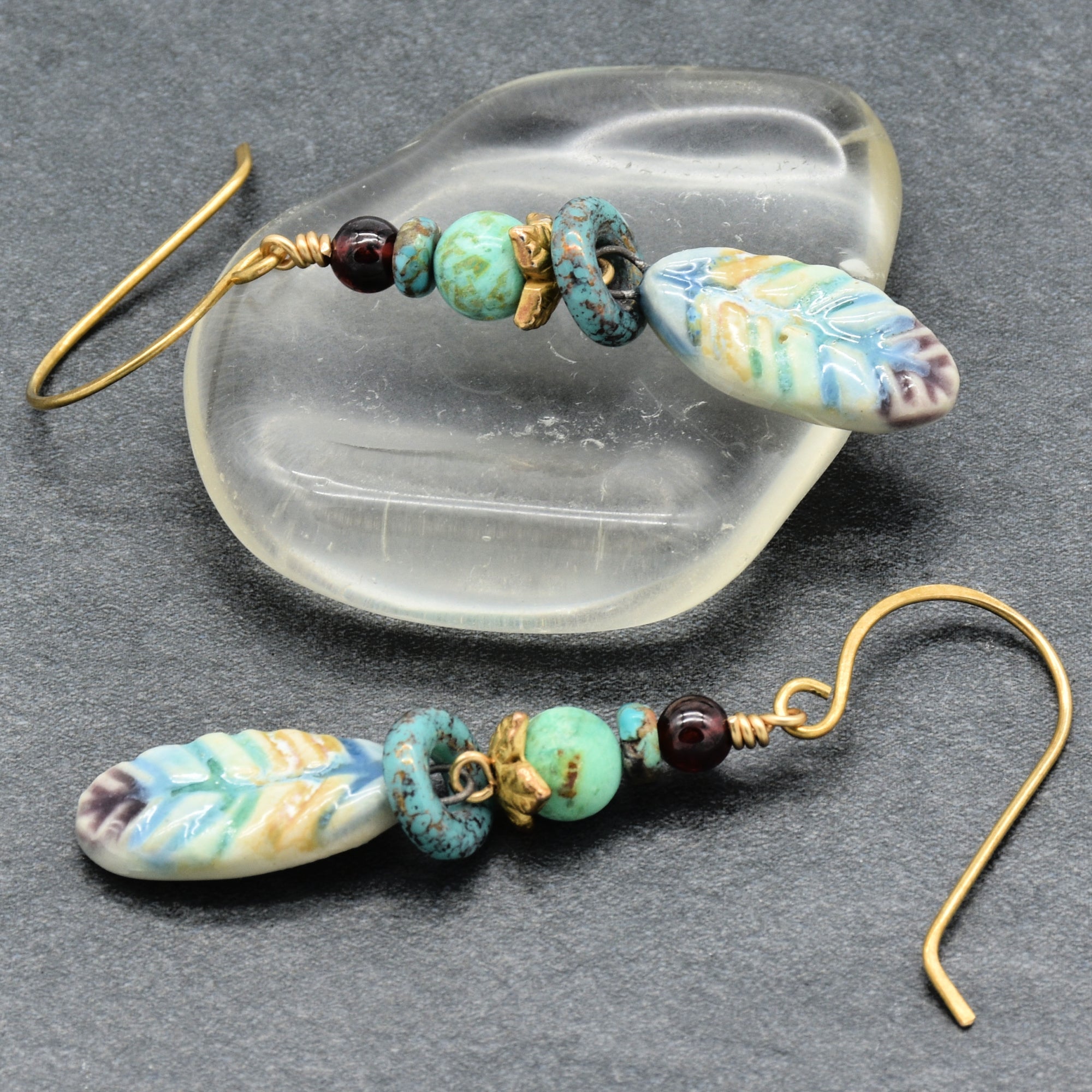 Pair of earrings with ceramic beads on a dark surface