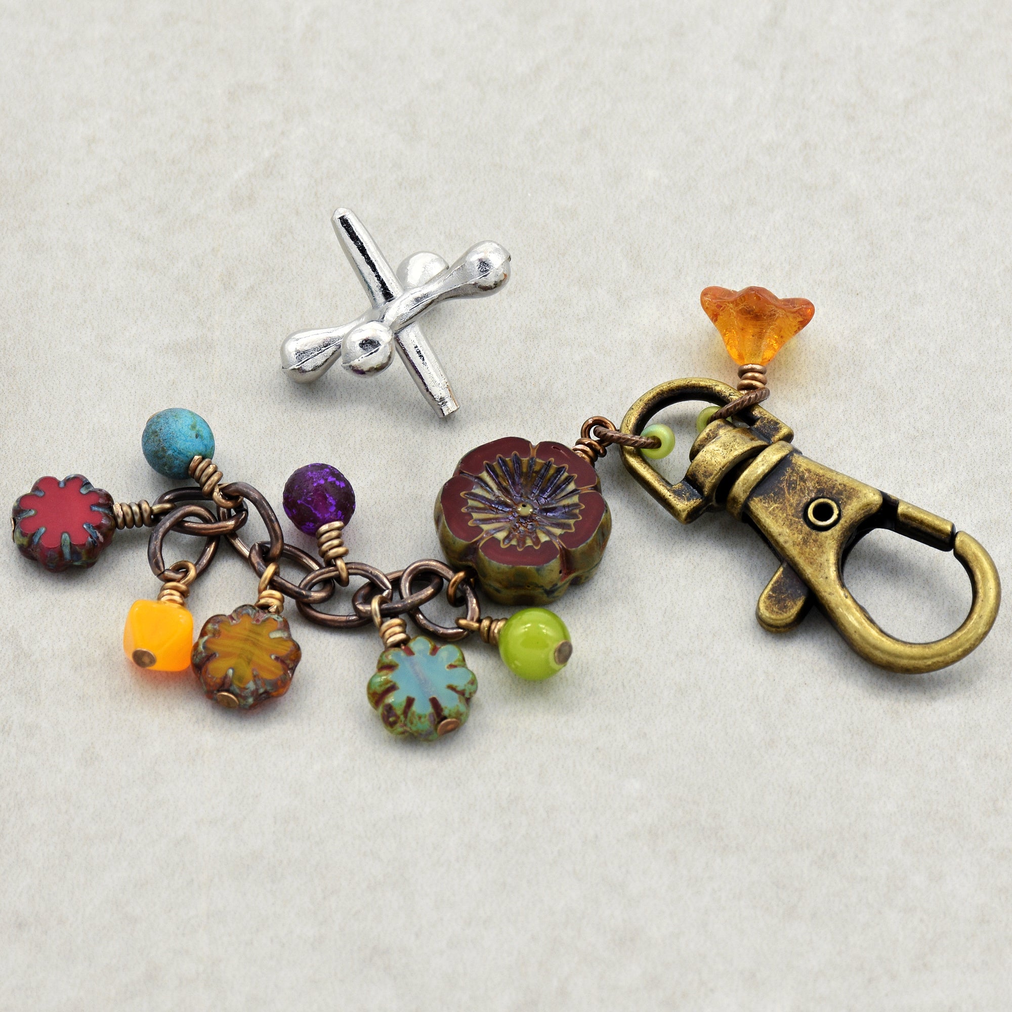 Colorful keychain with floral designs and a clasp on a light gray background