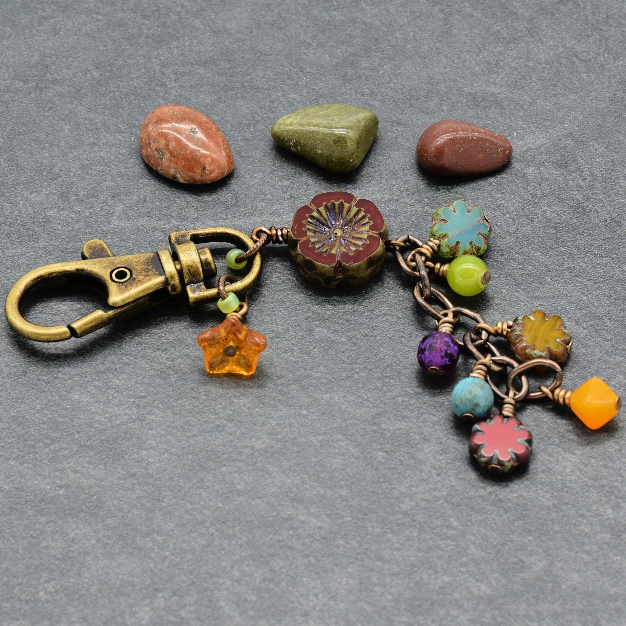 Colorful keychain with floral charms on a gray background