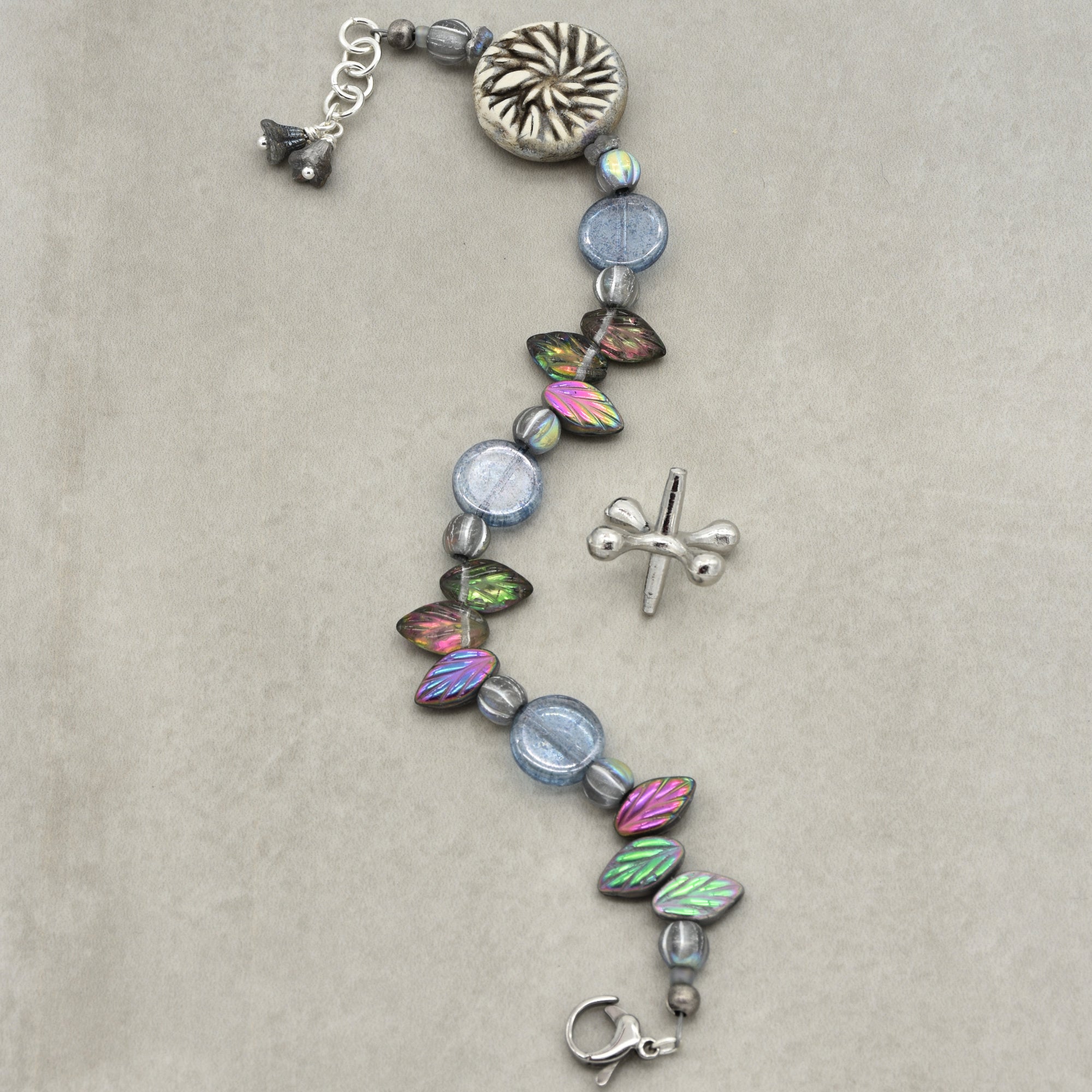 Bracelet with colorful beads and silver charms on a beige background