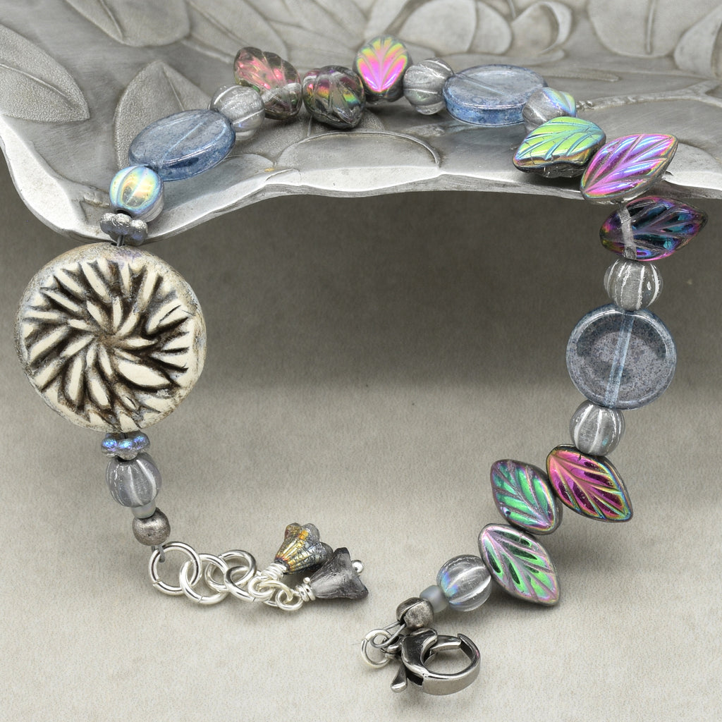 Bracelet with colorful beads and silver charm on a decorative stand
