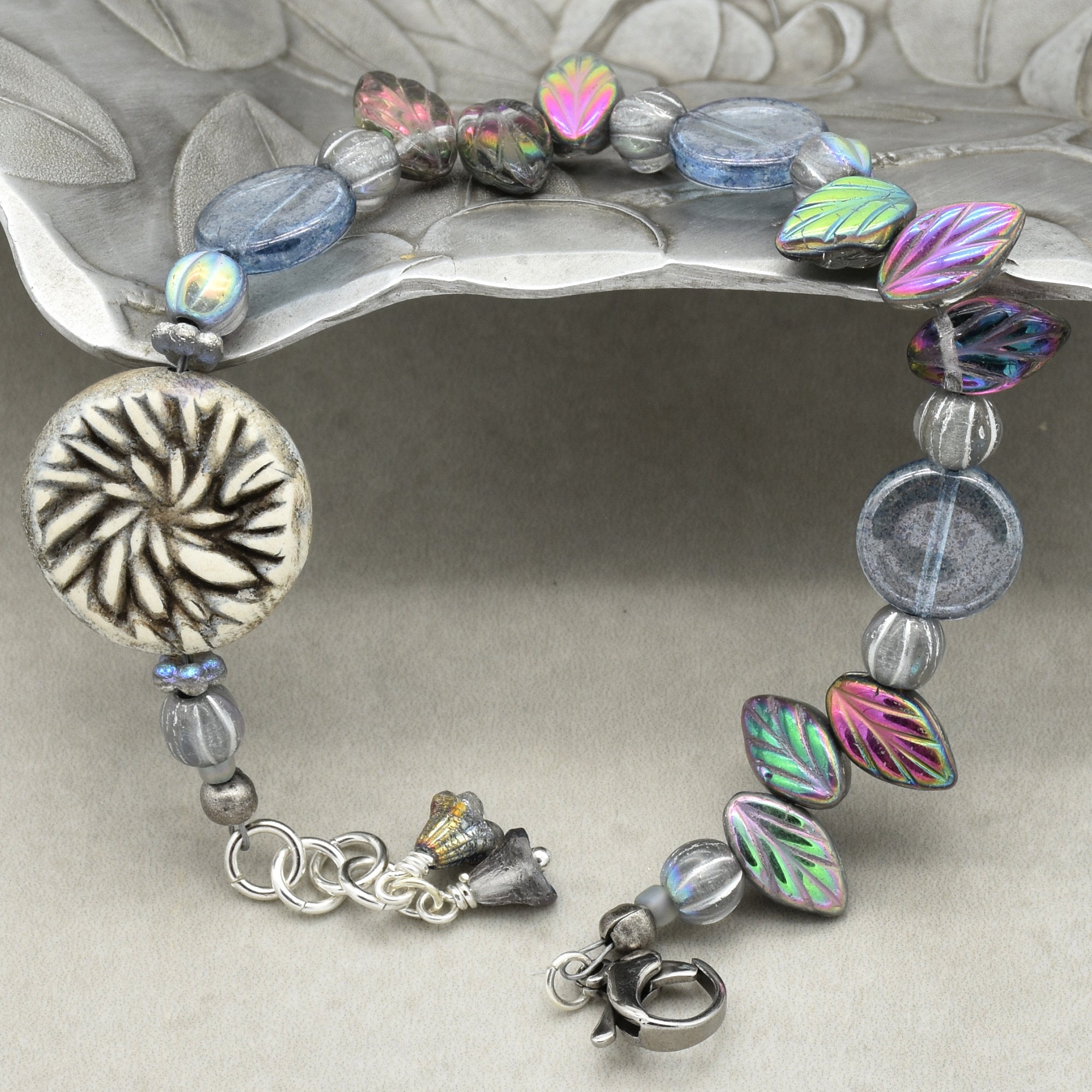 Bracelet with colorful beads and silver charm on a decorative stand