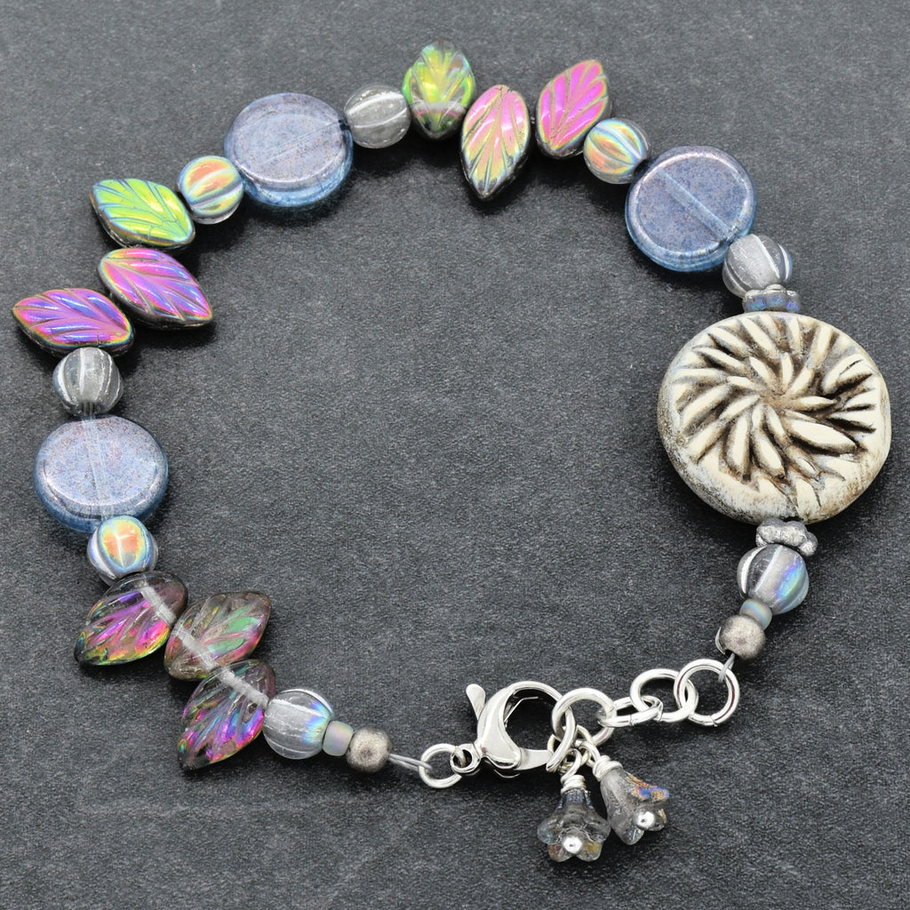 Beaded bracelet with colorful beads and a silver clasp on a dark background