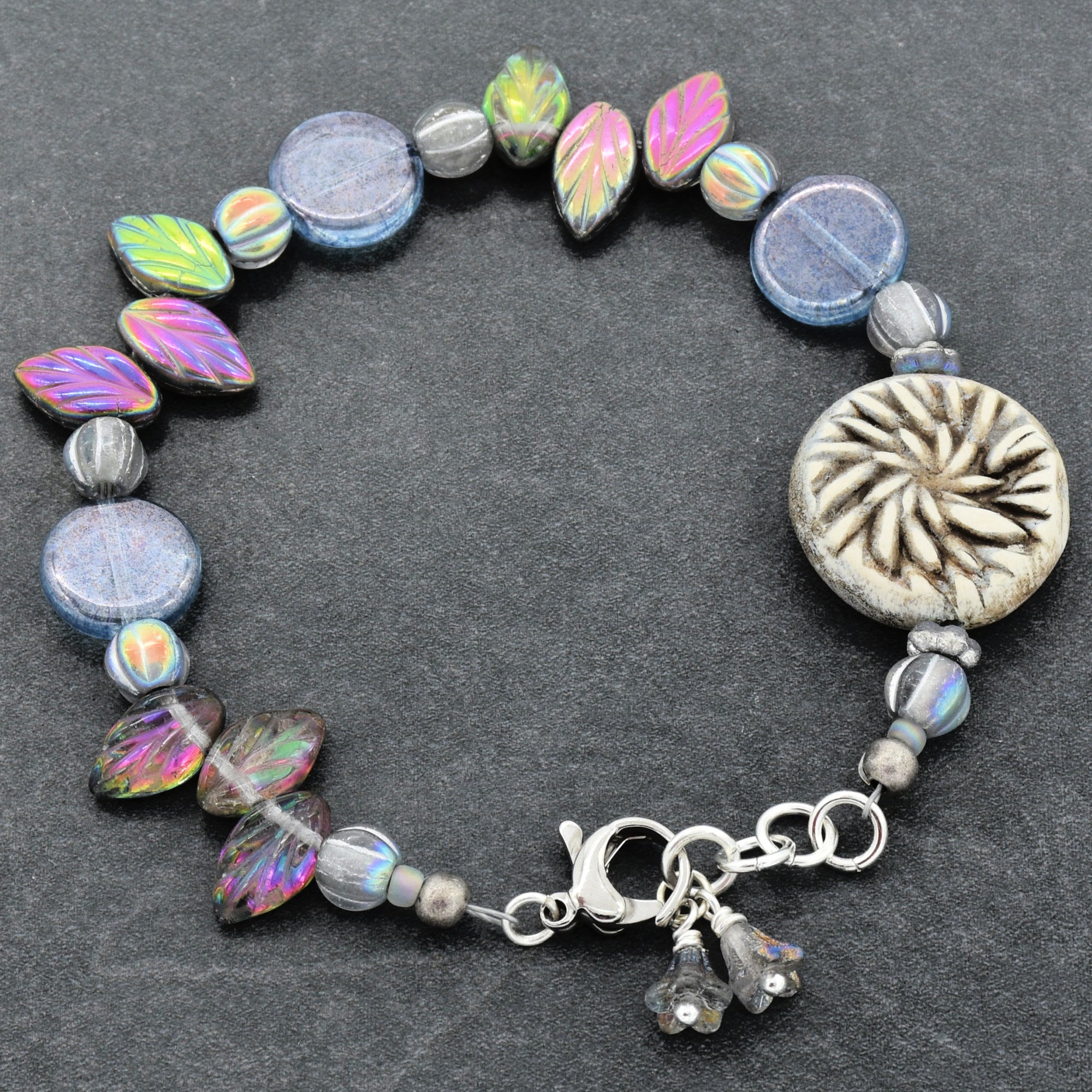 Beaded bracelet with colorful beads and a silver clasp on a dark background