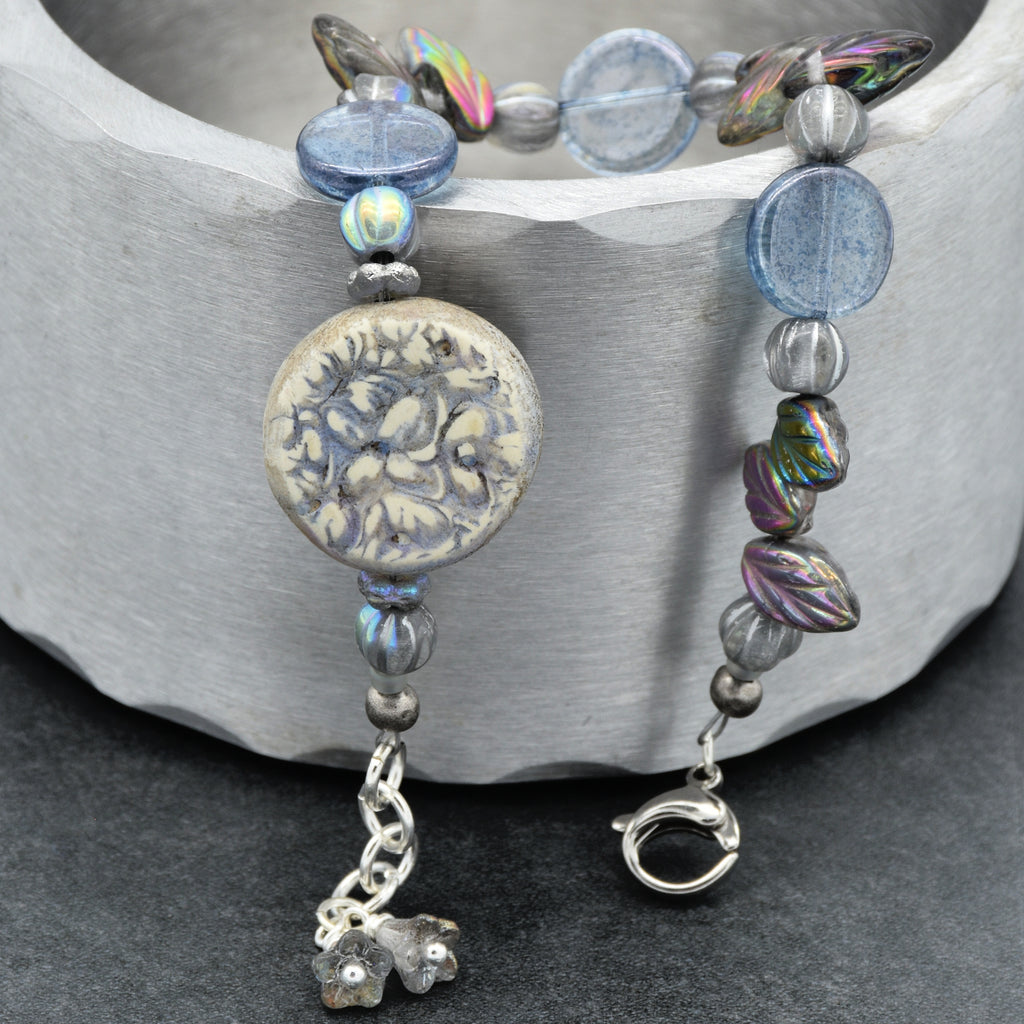 Beaded bracelet with decorative charm on a gray surface