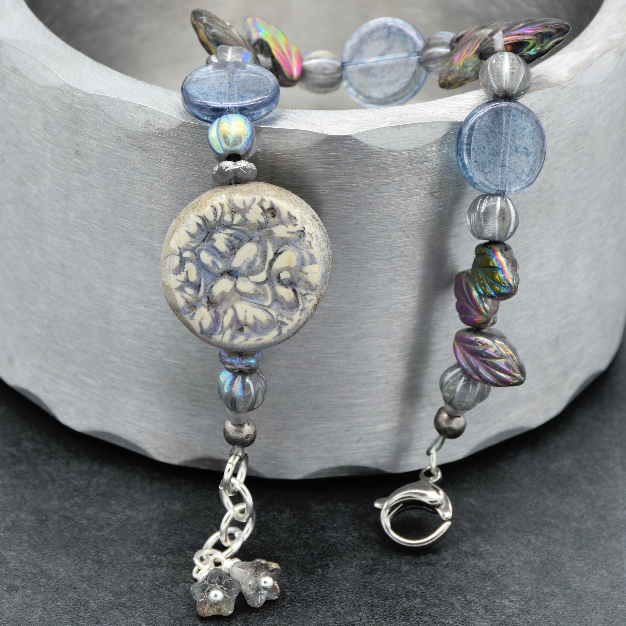 Beaded bracelet with decorative charm on a gray surface