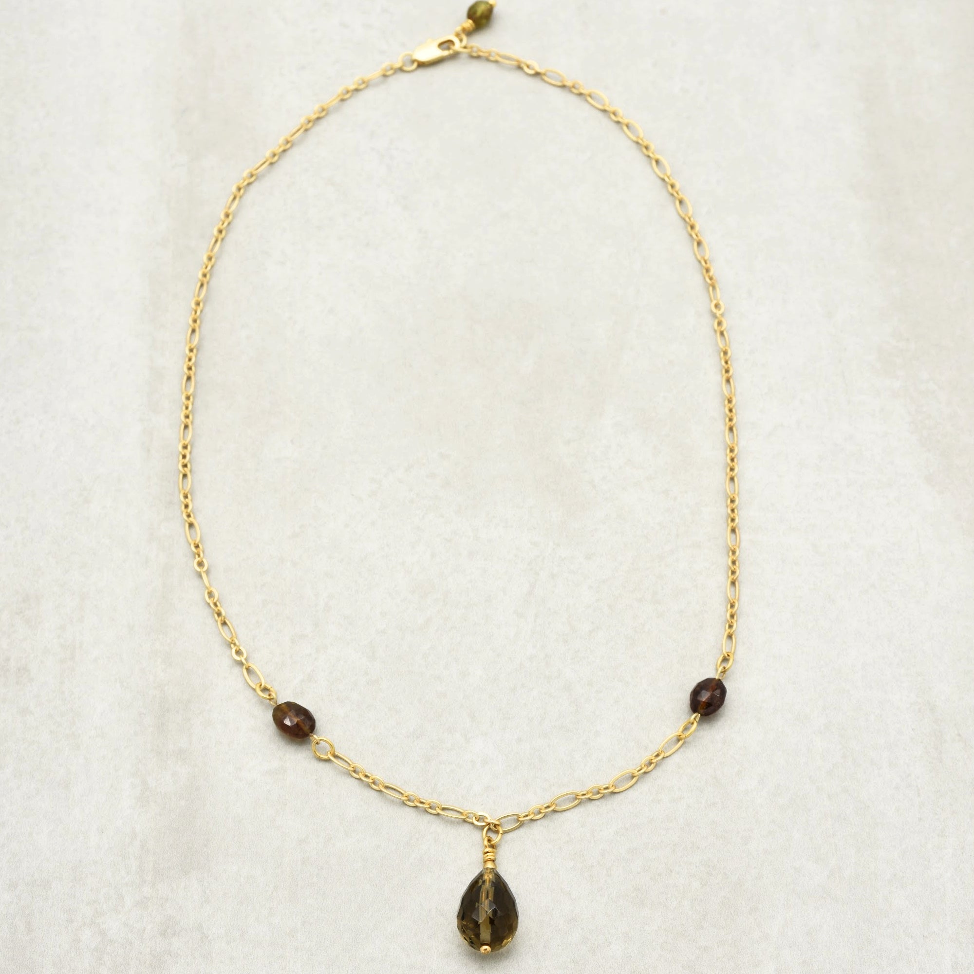 This image shows a necklace. The long chain with a clasp and the pendant hanging in the middle indicate that it is a necklace. It is not an earring or bracelet, as those would typically be smaller or differently shaped.