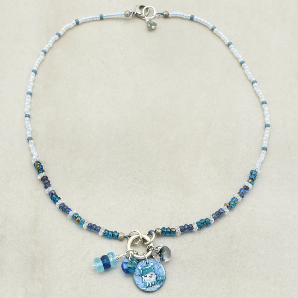 Festive beaded necklace with a blue charms on a beige background