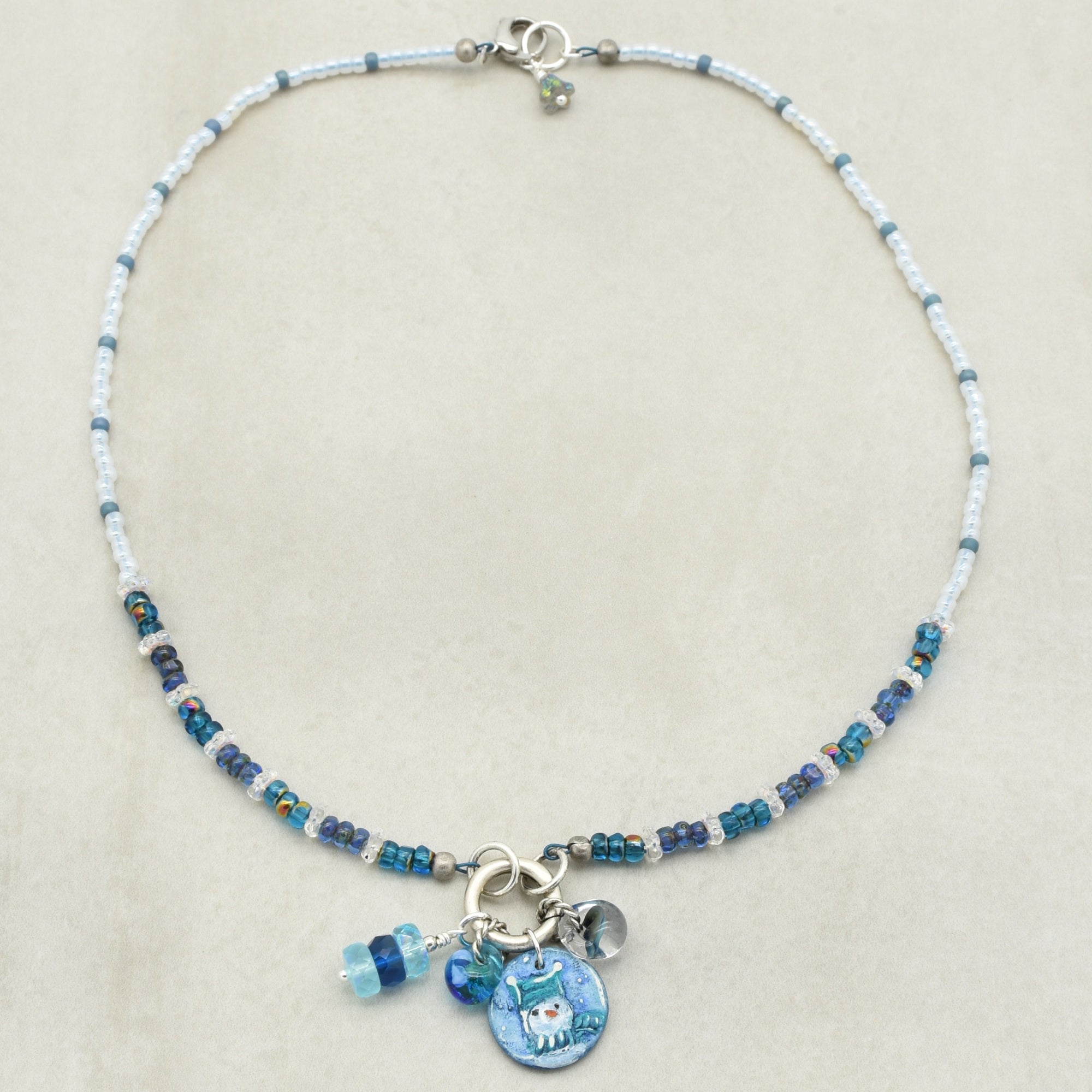 Festive beaded necklace with a blue charms on a beige background