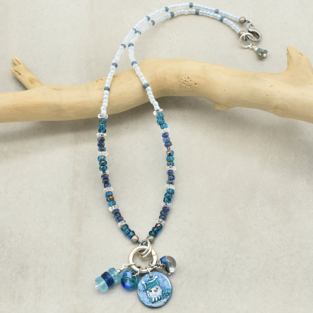 Festive beaded necklace with charms on a wooden branch