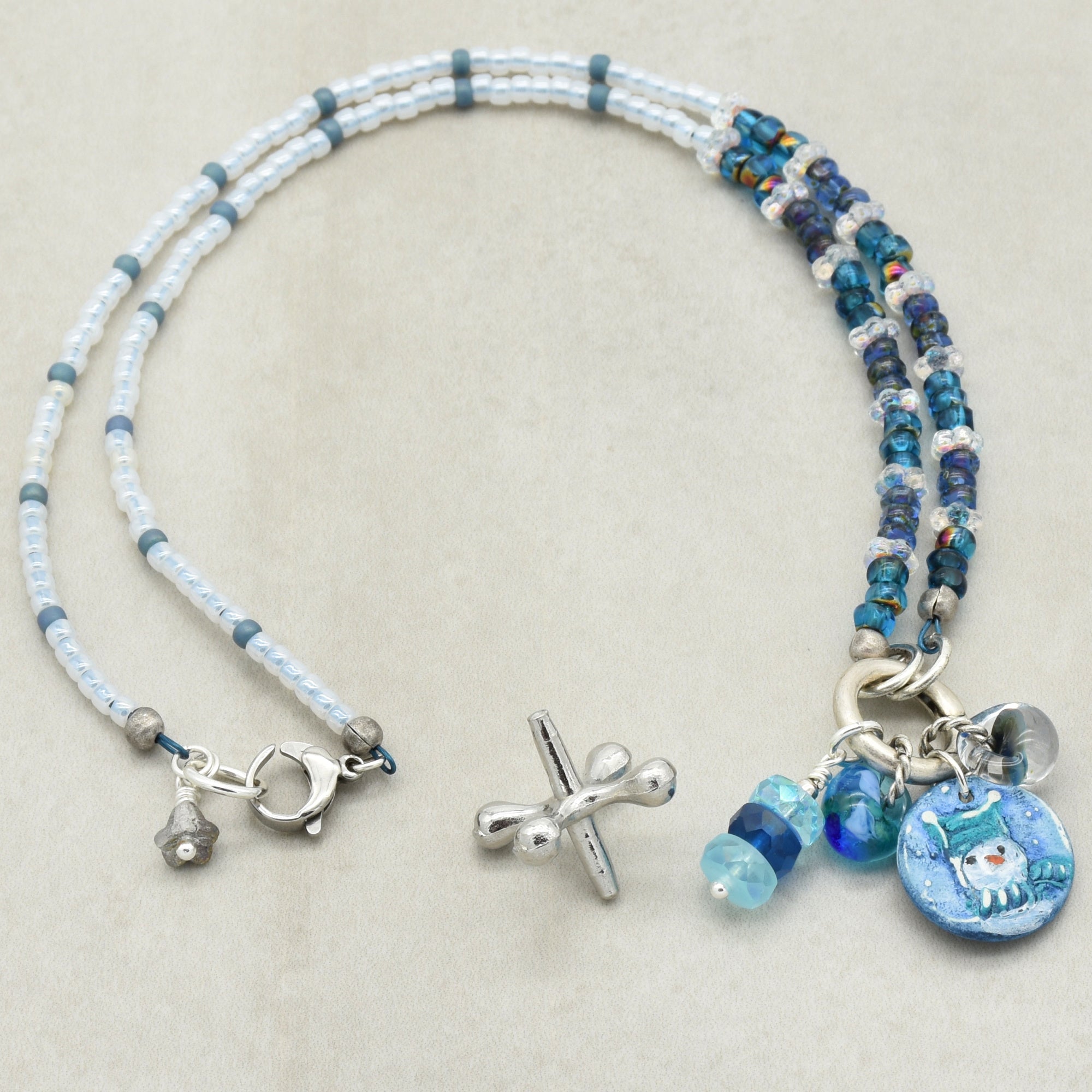 Festive beaded necklace with charms on a light gray background