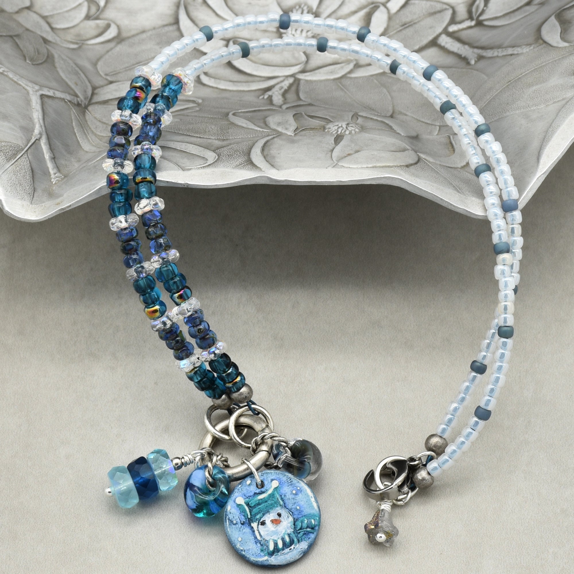 Beaded necklace with charms on a decorative plate