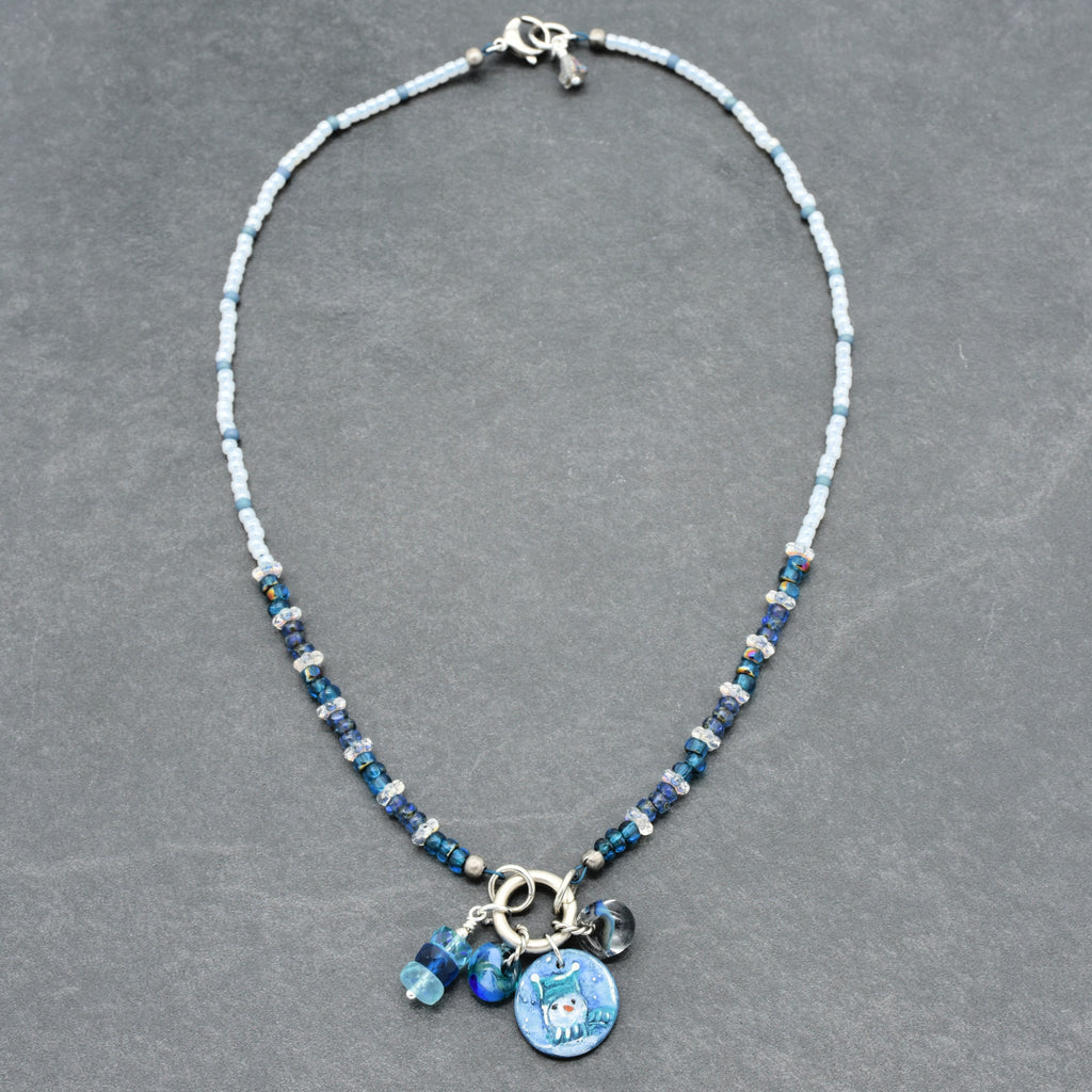 Necklace with blue beads and charms on a gray background