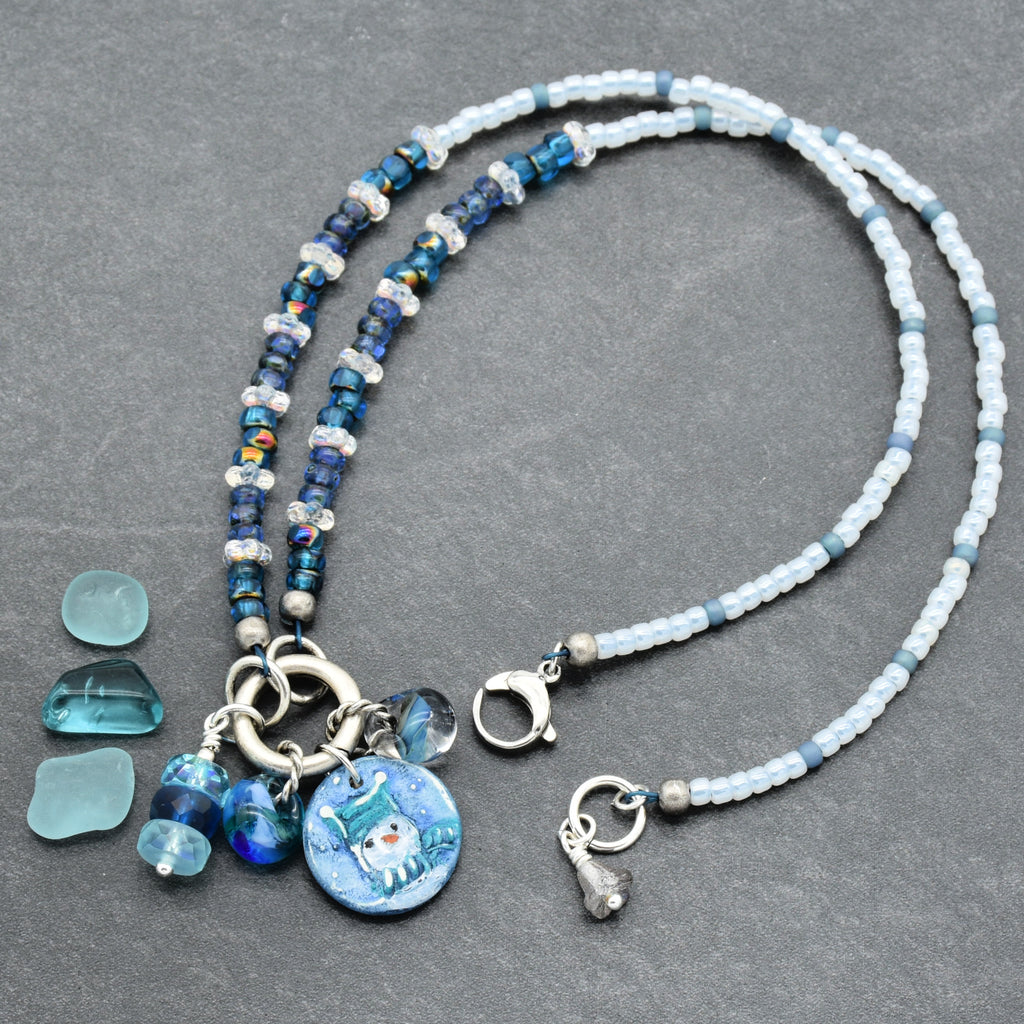 Festive necklace with blue beads and charms on a gray surface