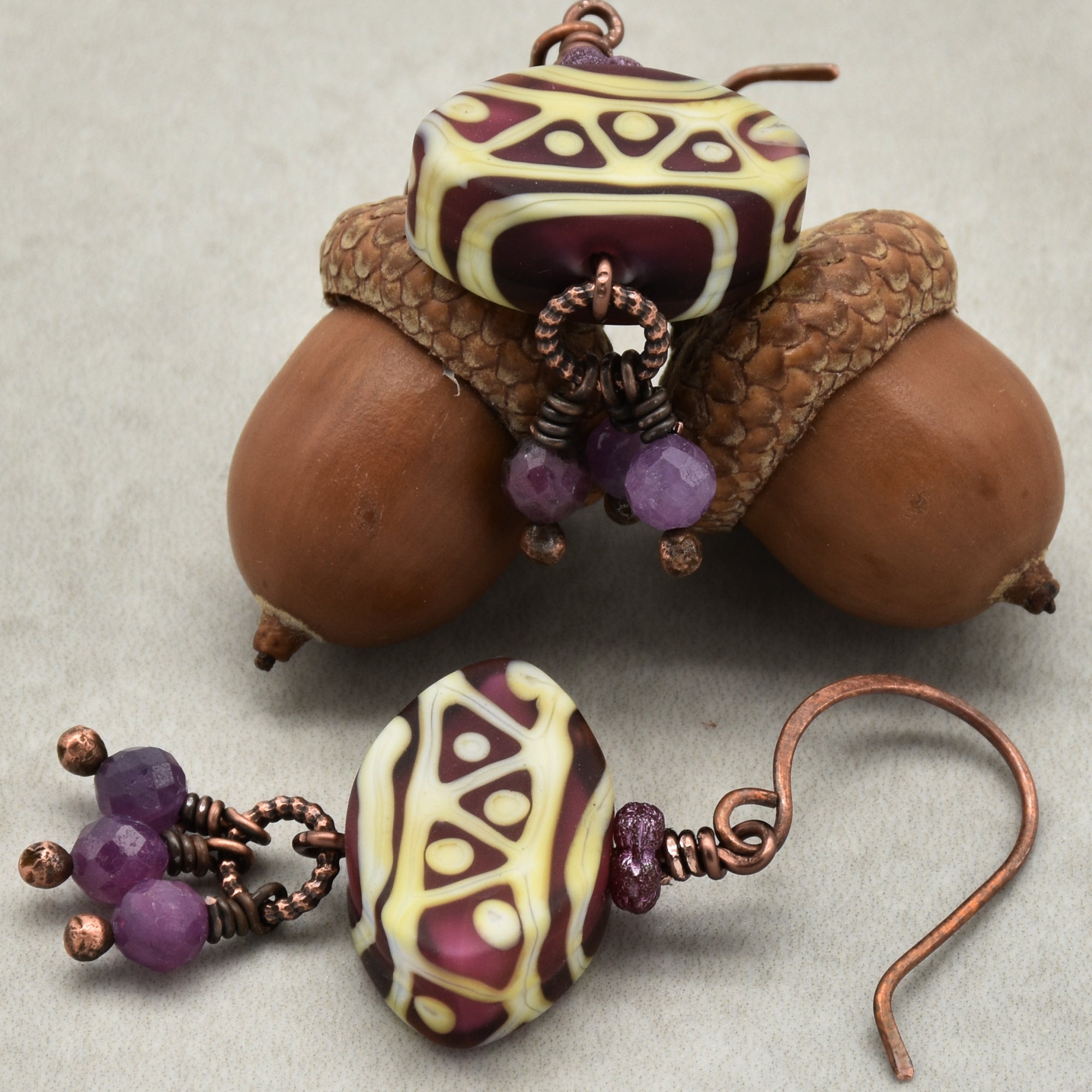 Pair of earrings with tribal bead design on a neutral background