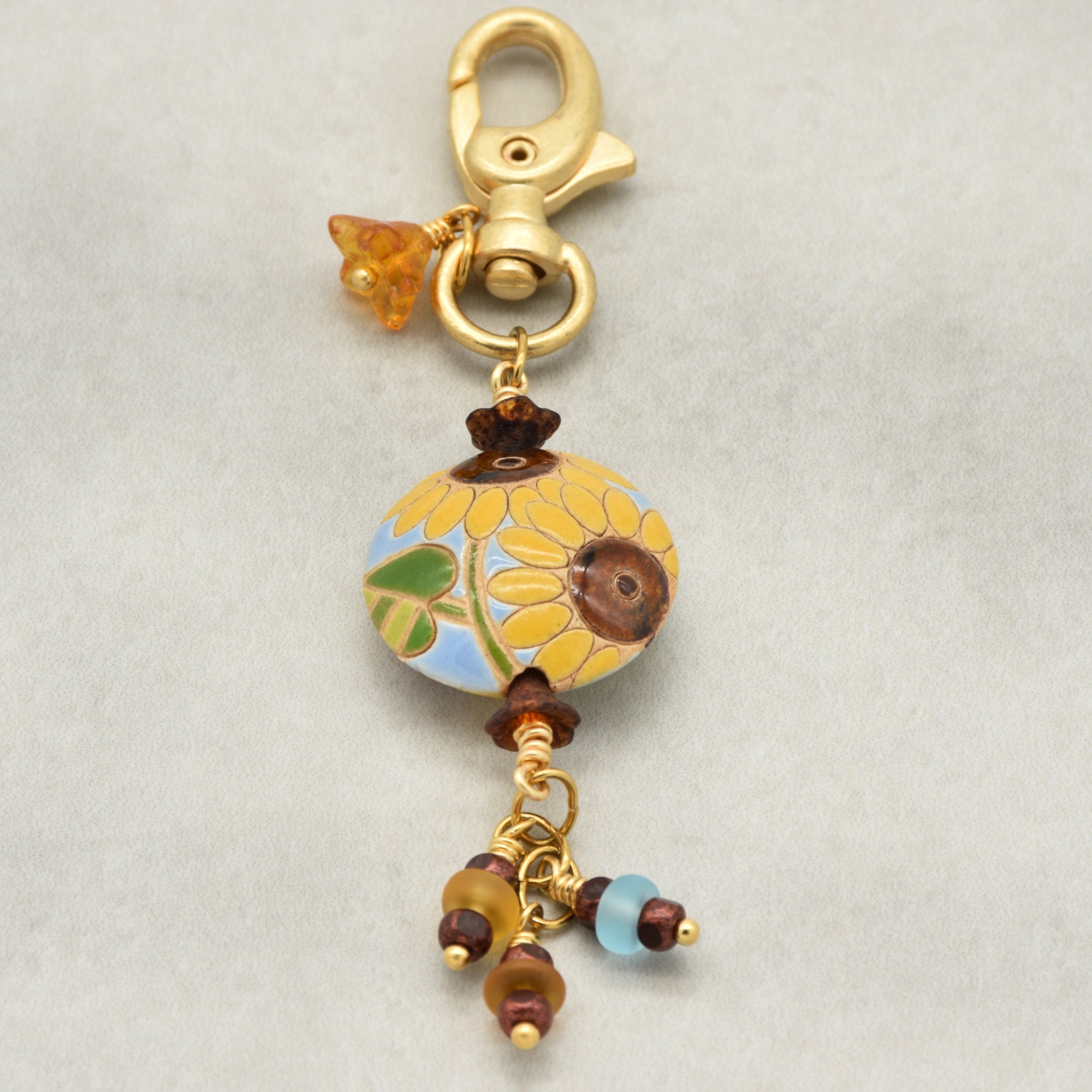 Colorful sunflower handbag charm with gold swivel lobster clasp on a light background - handmade with love by Ruby Acorn